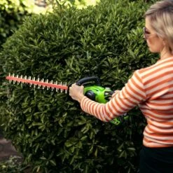 GreenWorks G40HT61K2 G-MAX 40V Cordless Hedge Trimmer (with 2Ah Battery & 2A Charger) (Bundle Builder) -Garden Tool Store greenworks g40ht61 hedge trimmer lifestyle woman 1 1